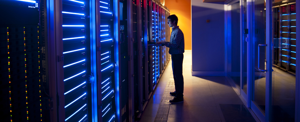 Engineer working at a rack in a datacentre aisle